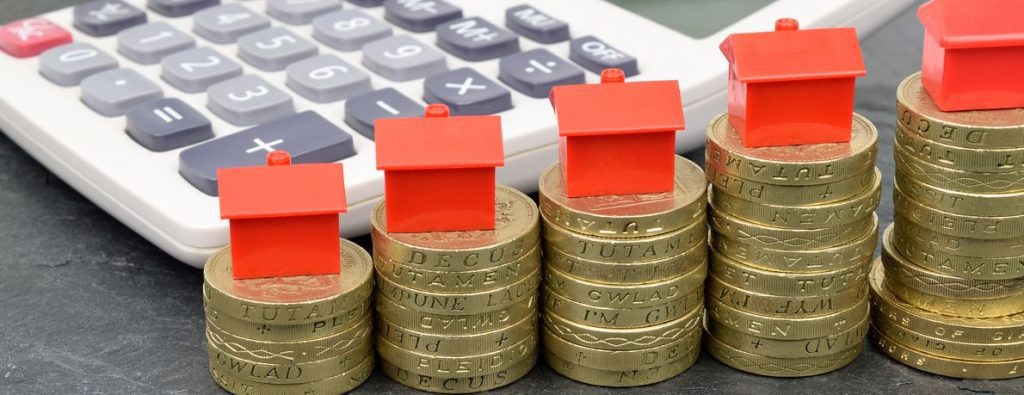 Stacks of Pound Coins with Monopoly Houses On